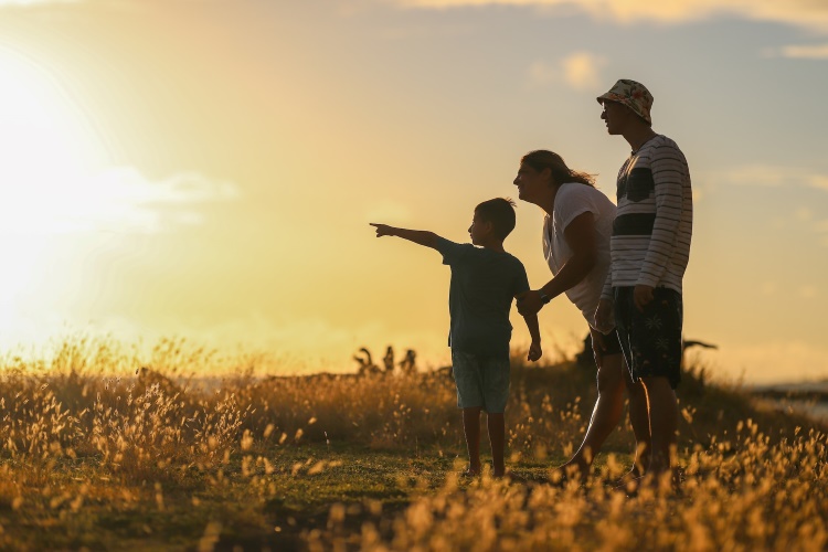 Familie bei Sonnenuntergang in einem Feld