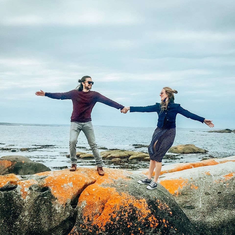 Zwei Reisende posen auf den roten Felsen der Bay of Fires