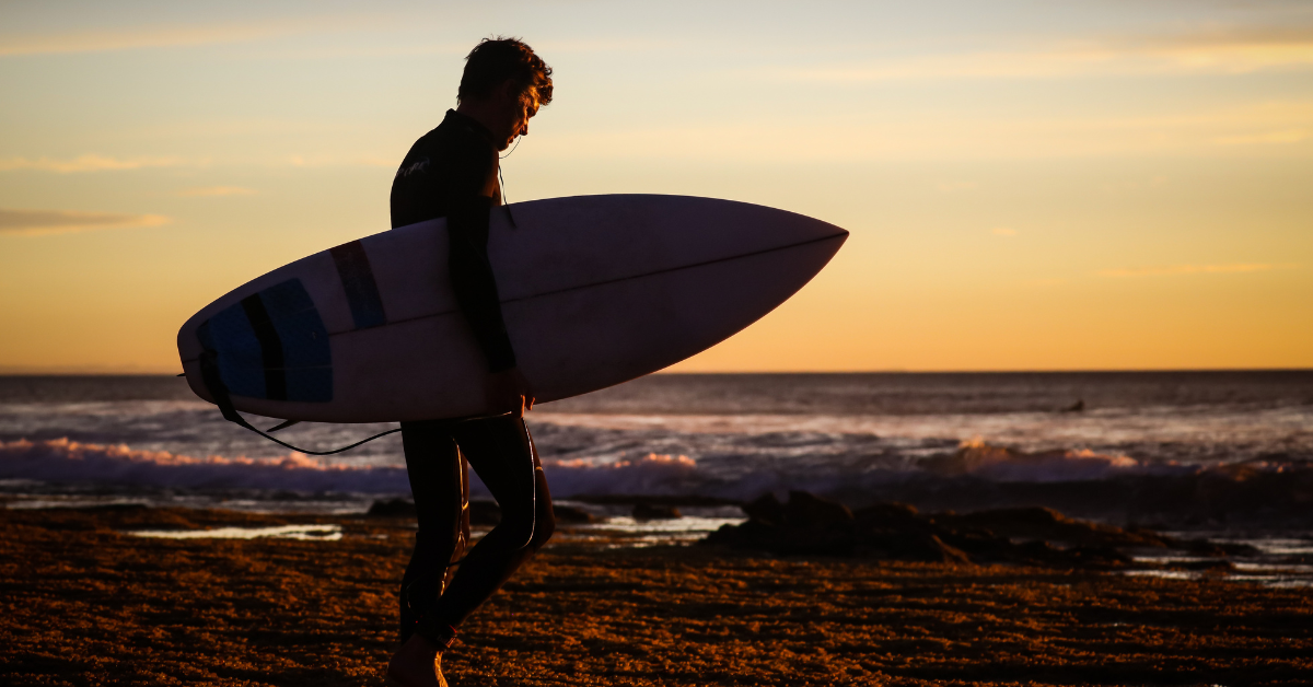 Surfer am Strand im Sonnenuntergang